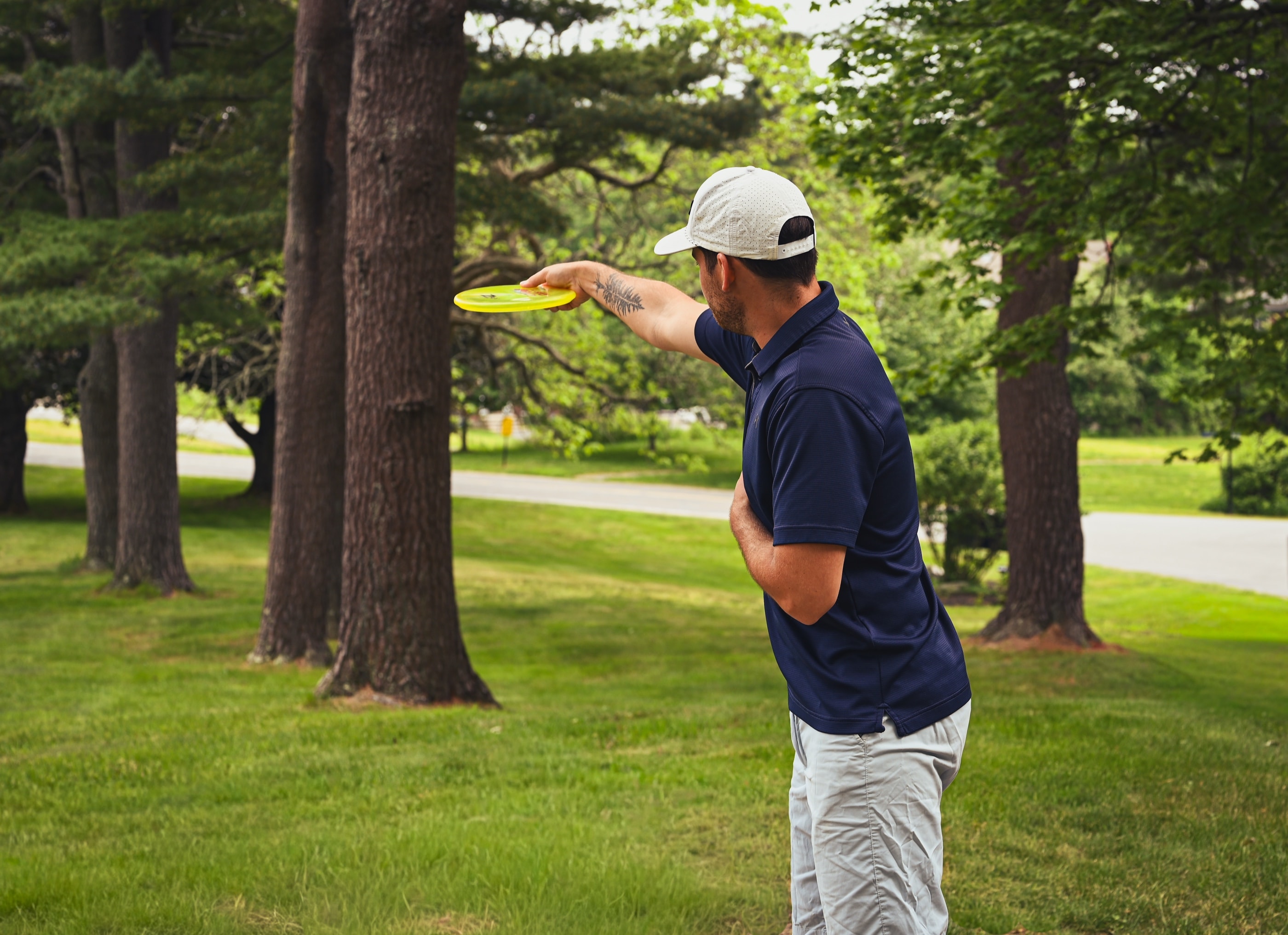A disc golfer mid-throw on a wooded course